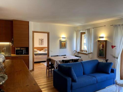 a living room with a blue couch and a table at Appartamento Chalet a Pinzolo in Pinzolo