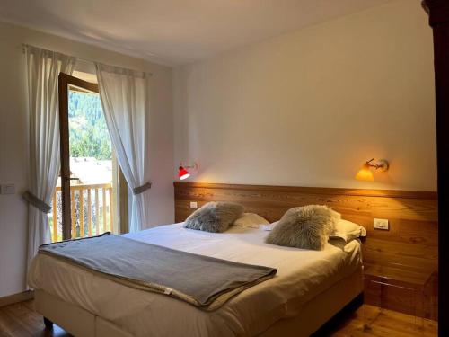 a bedroom with a bed with two furry pillows on it at Appartamento Chalet a Pinzolo in Pinzolo