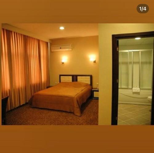 1 dormitorio con 1 cama y puerta corredera de cristal en GRAND ADANUS HOTEL, en Seyhan