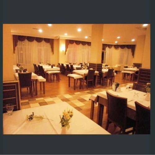 ein Esszimmer mit Tischen, Stühlen und einem Tisch in der Unterkunft GRAND ADANUS HOTEL in Seyhan