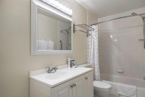 y baño con lavabo, aseo y espejo. en Dupont Circle 1BR nr U St Metro Glens Mkt WDC-176 en Washington