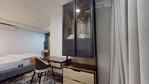 a bedroom with a bed and a desk with a mirror at YANNA APARTMENT BY KHALIQUES in Abuja