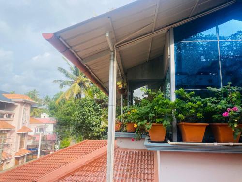 a balcony with potted plants on a building at Homestay - Heaven Aumgarden in Trivandrum