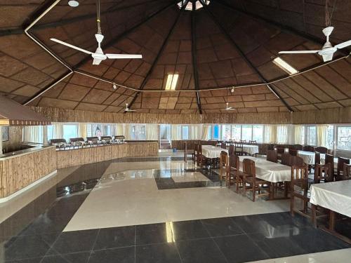 a dining room with tables and chairs and a ceiling at Hotel Jungle Lunar in Sauraha