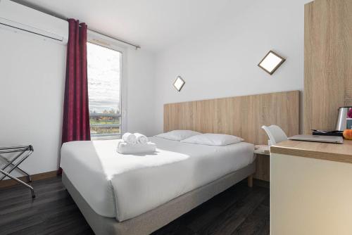 Habitación de hotel con cama y ventana en Hotel L'Abri en Le Puy-en-Velay