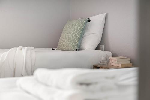 a white couch with a pillow and a side table at Logis Hôtel Restaurant L'Abri in Le Puy en Velay