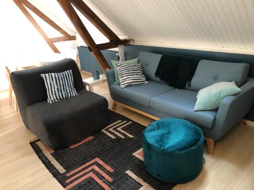 ein Wohnzimmer mit einem Sofa und einem Stuhl in der Unterkunft Numéro 7 in Le Tronquay