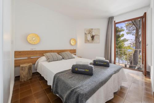 sypialnia z 2 łóżkami i dużym oknem w obiekcie El Faro w Port de Pollença
