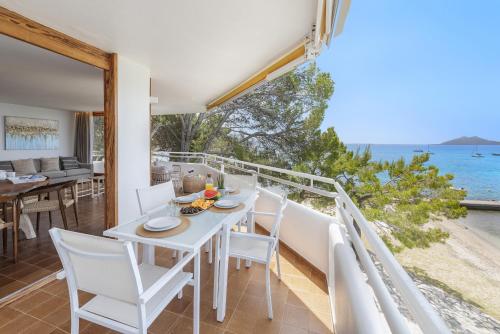 een witte eetkamer met uitzicht op de oceaan bij El Faro in Port de Pollença