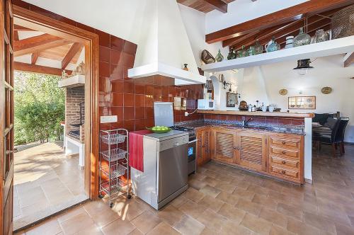 a kitchen with wooden cabinets and a stove top oven at Villa Can Deyá in Port de Pollensa