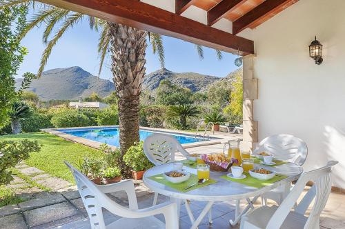a table with food on it next to a pool at Villa Can Deyá in Port de Pollensa