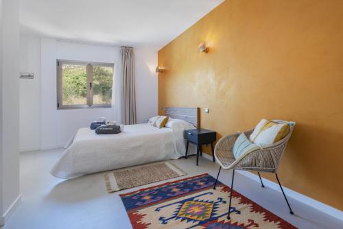 ポリェンサにあるVilla Boquerのベッドルーム1室(ベッド1台、椅子、窓付)