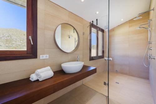 uma casa de banho com um lavatório e um espelho em Villa Vinya III em El Port