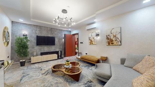 a living room with a couch and a tv at YANNA APARTMENT BY KHALIQUES in Abuja