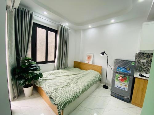 een slaapkamer met een bed en een plant erin bij Nhà 40C Hoàng Ngân in Hanoi