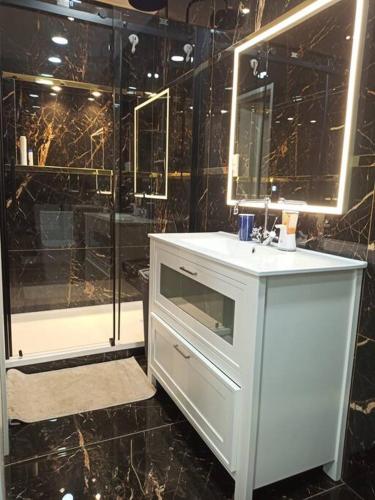 La salle de bains est pourvue d'un lavabo blanc et d'une douche. dans l'établissement Sunny studio, à Esplugues de Llobregat