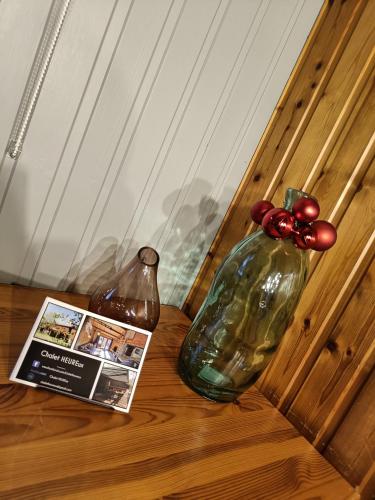 a book and two glass vases on a table at Chalet HEUREux in Somme-Leuze