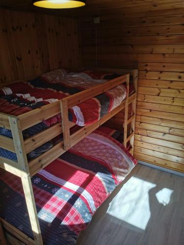 a bedroom with two bunk beds in a cabin at Chalet HEUREux in Somme-Leuze