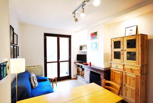 uma sala de estar com um sofá azul e uma mesa em L' Orso Felice - alloggio turistico a Campo Felice em Collimento