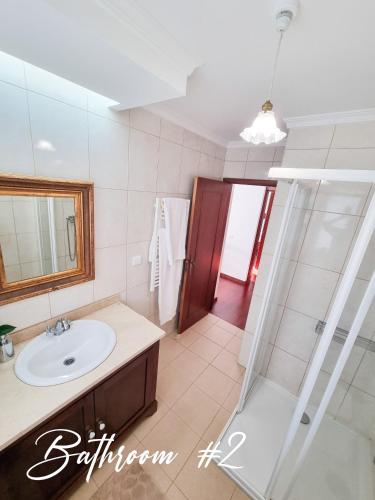 a bathroom with a sink and a shower at Casa da Ladeira in Fajã da Ovelha