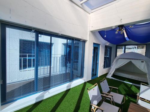 a screened in porch with chairs and a tent at Yeosu Blueara Premium Pool Villa in Yeosu