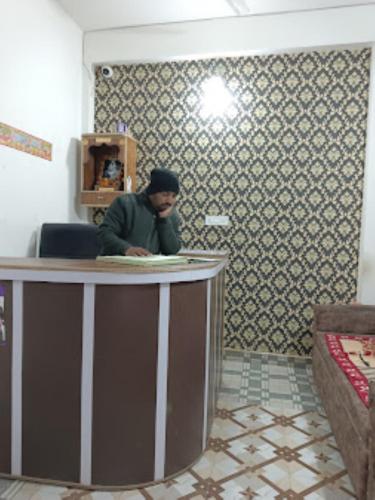 Un uomo seduto al bancone in una stanza di Hotel Sai Prabha, Bhind a Bhind