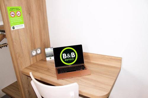 a laptop computer sitting on top of a wooden desk at B&B HOTEL Montélimar Sud in Montélimar