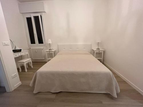 ein weißes Schlafzimmer mit einem Bett und 2 Tischen in der Unterkunft bandbinbologna in Bologna