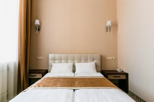 een bed in een kamer met 2 nachtkastjes en een bed sidx sidx sidx bij MyLINE relax complex in Astana