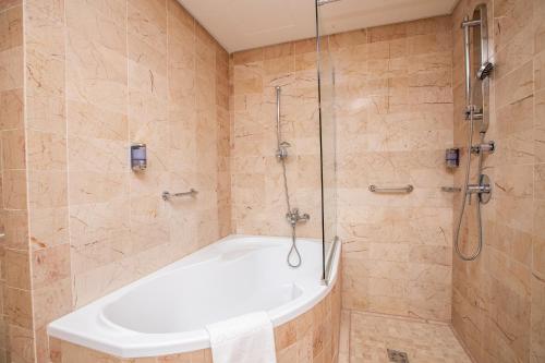 a bathroom with a bath tub and a shower at Hotel Lycium Debrecen in Debrecen