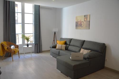 a living room with a gray couch and a table at MN9 Tarraco in Tarragona