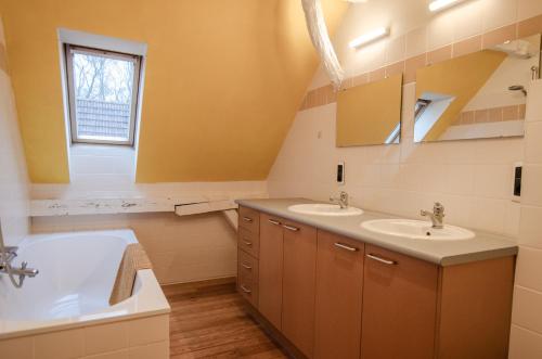 a bathroom with two sinks and a tub at Vakantiewoning De Luysmolen in Bocholt