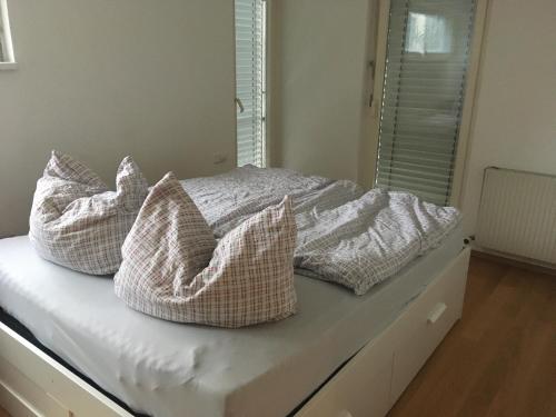 uma cama com almofadas em cima em Central em Dornbirn