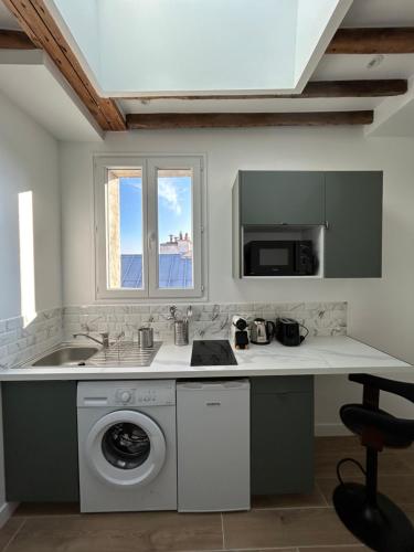 une cuisine avec un évier et une machine à laver dans l'établissement Notre-Dame de Paris - Ile de la Cité, à Paris