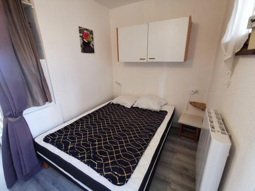une petite chambre avec un lit dans une pièce dans l'établissement 138 Thalacap C2, au Cap d'Agde