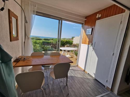 Cette chambre dispose d'une table, de chaises et d'un balcon. dans l'établissement 138 Thalacap C2, au Cap d'Agde
