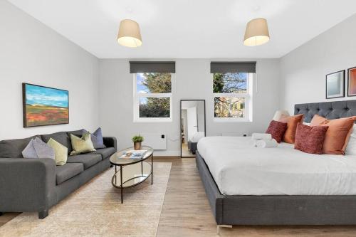 a bedroom with a large bed and a couch at Stunning and Extremely spacious 1bed flat in Tooting in London