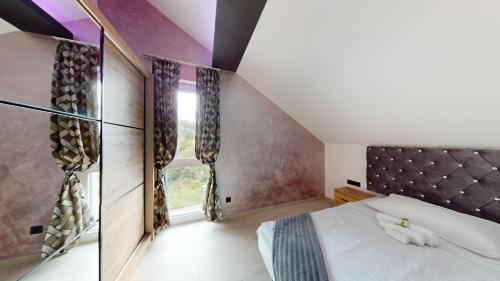 a bedroom with a large bed and a window at Resort TimAJA - pool, massage pool, sauna in Trebnje