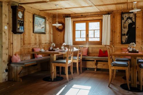a dining room with wooden walls and a table and chairs at Gästehaus Fritz in Mittelberg