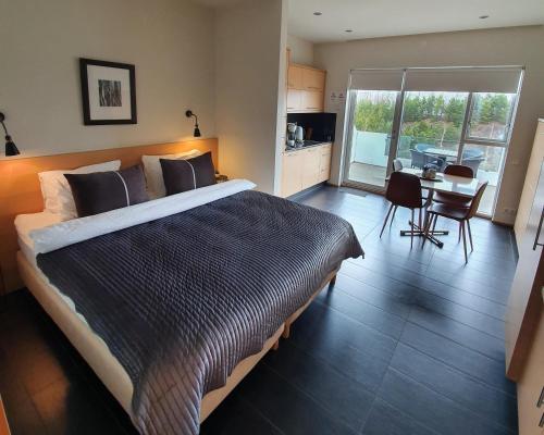 een slaapkamer met een groot bed en een tafel met stoelen bij Saeluhus Apartments & Houses in Akureyri