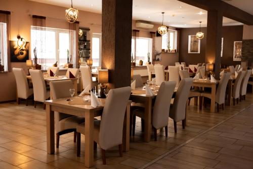 a dining room with wooden tables and chairs at Hotel Mazuria Country & SPA in Mrągowo
