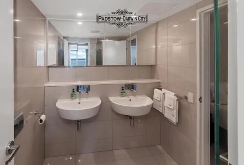 a bathroom with two sinks and a mirror at "PADSTOW" Top Location & Views at PenthousePads in Darwin