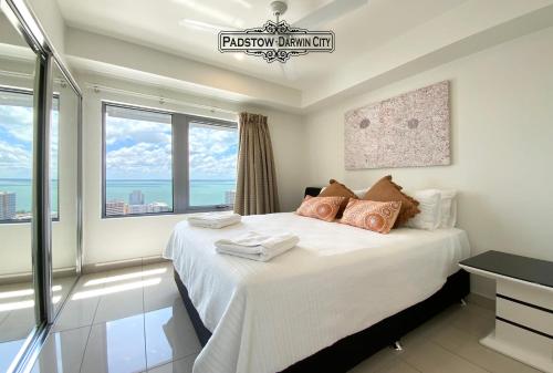 a bedroom with a bed with a view of the ocean at "PADSTOW" Top Location & Views at PenthousePads in Darwin