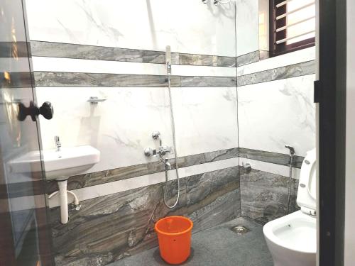 a bathroom with a shower and a sink and a toilet at GOPURAM in Trivandrum