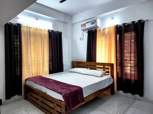 a bedroom with a bed with curtains and a heater at GOPURAM in Trivandrum