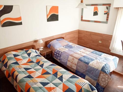 1 Schlafzimmer mit 2 Betten und Wandmalereien in der Unterkunft Casa chalet a minutos de Claromecó, Balneario Reta, Balneario Orense in San Francisco de Bellocq