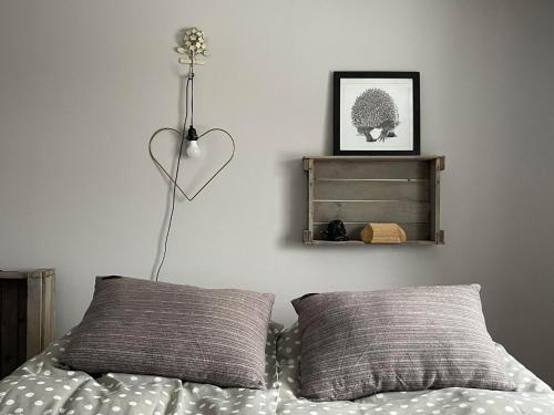 a bedroom with a bed with two pillows and a heart lamp at Ristiku Guesthouse in Kuressaare