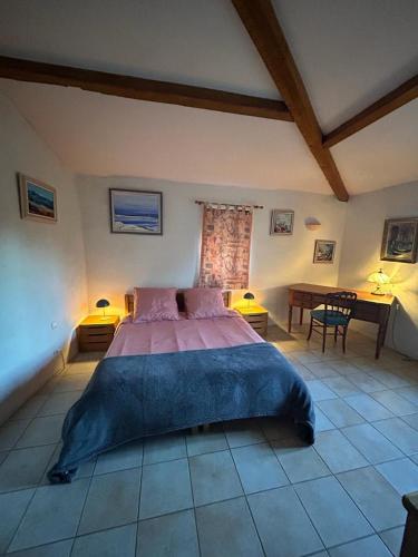 une chambre avec un grand lit et une table dans l'établissement Mas le Canton, à Saint-Jean-du-Gard