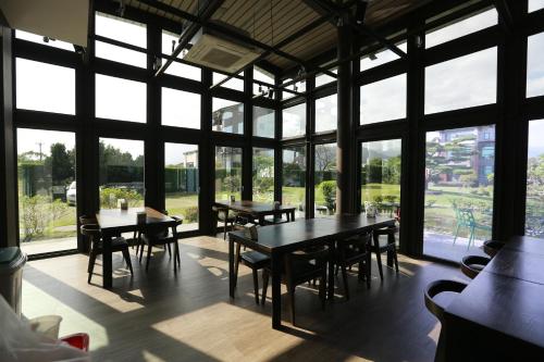 a dining room with tables and chairs and large windows at Skyline B&B in Yuanshan