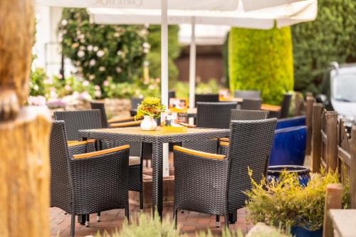 an outdoor table with chairs and an umbrella at Akzent Hotel Berlin in Bad Bevensen